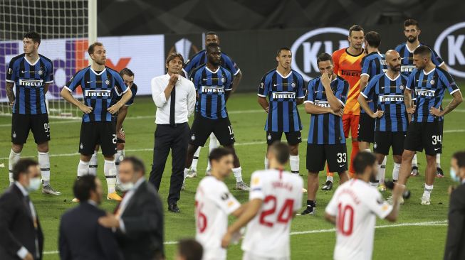 Pelatih kepala Inter Milan Antonio Conte dan para pemain Inter bereaksi setelah Sevilla memenangkan pertandingan sepak bola final Liga Eropa UEFA Sevilla melawan Inter Milan di RheinEnergieStadion, Cologne, Jerman pada (21/8/2020). [Lars Baron / POOL / AFP]