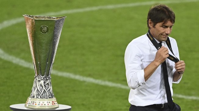 Pelatih kepala Inter Milan Antonio Conte berjalan melewati trofi setelah kalah dalam pertandingan final sepak bola Liga Eropa UEFA Sevilla melawan Inter Milan di RheinEnergieStadion, Cologne, Jerman pada (21/8/2020). [Ina Fassbender / POOL / AFP]