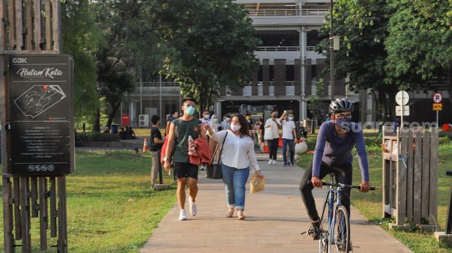 Warga mendatangi area Hutan Kota Gelora Bung Karno, Senayan, Jakarta Sekatan, Minggu (23/8). [Suara.com/Alfian Winanto]