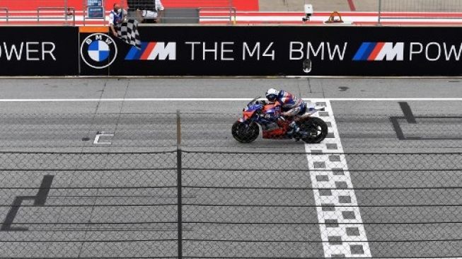 Pembalap Red Bull KTM Tech 3 Miguel Oliveira melewati garis finis guna menjuarai MotoGP Styria di sirkuit Red Bull Ring, Spielberg, Austria. Joe Klamar / AFP