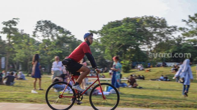 Warga bersepeda di area Hutan Kota Gelora Bung Karno, Senayan, Jakarta Sekatan, Minggu (23/8). [Suara.com/Alfian Winanto]