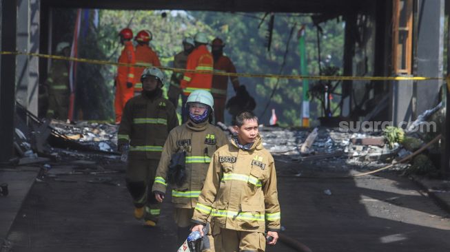 Petugas Damkar keluar usai melakukan proses pendinginan di gedung utama Kejaksaan Agung Republik Indonesia di Jalan Sultan Hasanuddin, Jakarta Selatan, Minggu (23/8). [Suara.com/Alfian Winanto]