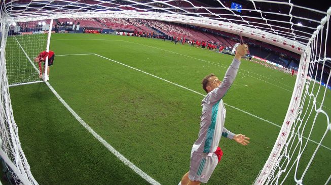 Kiper Bayern Munich, Manuel Neuer memotong gawang setelah pertandingan final Liga Champions antara Paris Saint-Germain melawan Bayern Munich di Luz stadium, Lisbon, Senin (24/8/2020) dini hari WIB. [LLUIS GENE / POOL]
