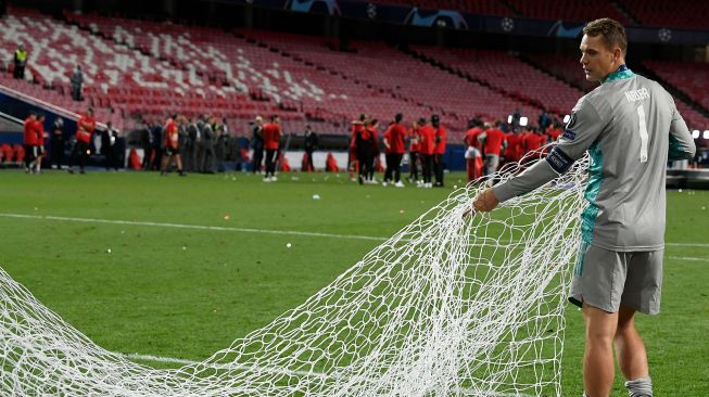 Kiper Bayern Munich, Manuel Neuer memotong gawang setelah pertandingan final Liga Champions antara Paris Saint-Germain melawan Bayern Munich di Luz stadium, Lisbon, Senin (24/8/2020) dini hari WIB. [LLUIS GENE / POOL]
