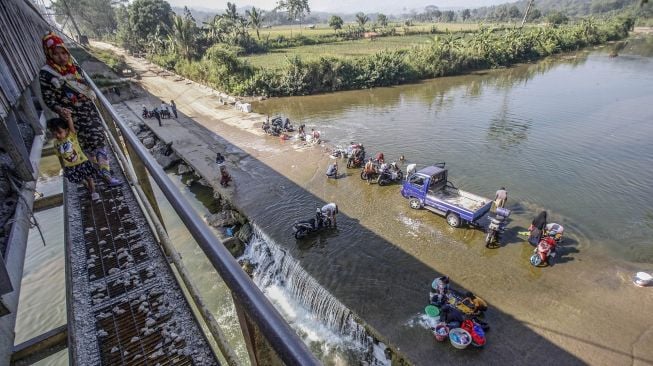 Sejumlah warga mencuci pakaian di aliran Sungai Cileungsi, Citeureup, Bogor, Jawa Barat, Selasa (25/8/2020).  [ANTARA FOTO/Yulius Satria Wijaya]
