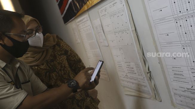 Komisioner KPU Evi Novida Ginting Manik (kiri) didampingi petugas KPU melakukan uji coba penghitungan data suara menggunakan aplikasi rekapitulasi elektronik (Sirekap) di Gedung Komisi Pemilihan Umum Republik Indonesia, Jakarta, Selasa (25/8/2020). [Suara.com/Angga Budhiyanto]