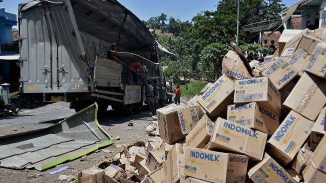 Petugas derek mengevakuasi truk pengangkut susu kemasan yang terguling di Nagreg, Kabupaten Bandung, Jawa Barat, Selasa (25/8/2020).  [ANTARA FOTO/Candra Yanuarsyah]