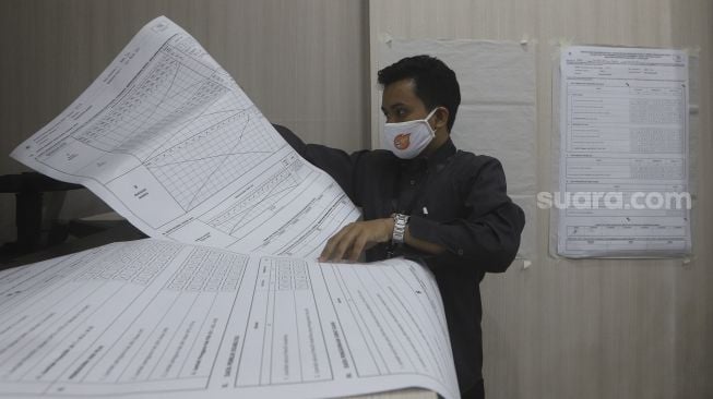 Petugas Komisi Pemilihan Umum (KPU) menyiapkan kertas data suara saat uji coba penghitungan data suara menggunakan aplikasi rekapitulasi elektronik (Sirekap) di Gedung Komisi Pemilihan Umum Republik Indonesia, Jakarta, Selasa (25/8/2020). [Suara.com/Angga Budhiyanto]