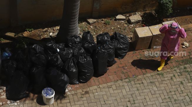 Tim medis mengemas sampah medis di Gelanggang Olahraga Remaja (GOR) Tambora, Jakarta, Rabu (26/8/2020). [Suara.com/Angga Budhiyanto]