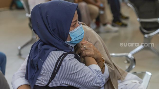 Adik Vicky Prasetyo memeluk sang Ibunda yang menangis saat mengikuti sidang kasus penggrebekan di Pengadilan Negeri Jakarta Selatan, Rabu (26/8). [Suara.com/Alfian Winanto]