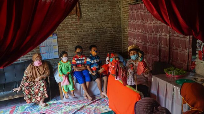 Seorang anak menunjukkan wayang klaras hasil buatannya sendiri di Desa Karanglo, Kecamatan Cilongok, Kabupaten Banyumas, Rabu (25/8/2020). (Suara.com/Anang Firmansyah)