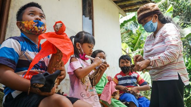 Nini Tarsih pentas mendongeng dengan menggunakan media wayang klaras di kediamannya, Desa Karanglo, Kecamatan Cilongok, Kabupaten Banyumas, Rabu (25/8/2020). (Suara.com/Anang Firmansyah)