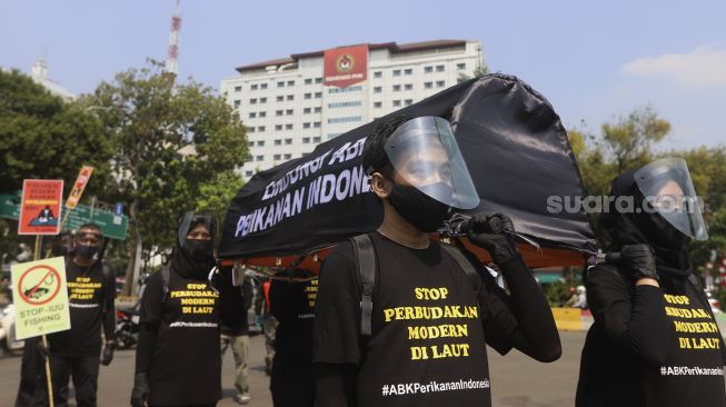 Aktivis buruh yang tergabung dalam Serikat Buruh Migran Indonesia (SBMI) dan Greenpeace Indonesia melakukan aksi damai di depan Istana Merdeka, Jakarta, Kamis (27/8/2020). [Suara.com/Angga Budhiyanto]