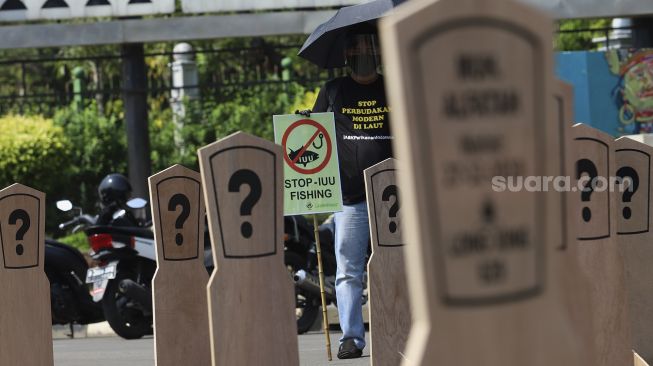 Aktivis buruh yang tergabung dalam Serikat Buruh Migran Indonesia (SBMI) dan Greenpeace Indonesia membawa poster saat melakukan aksi damai di depan Istana Merdeka, Jakarta, Kamis (27/8/2020). [Suara.com/Angga Budhiyanto]