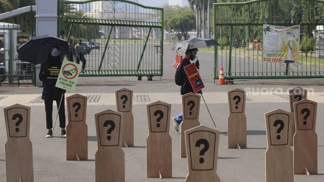 Aktivis buruh yang tergabung dalam Serikat Buruh Migran Indonesia (SBMI) dan Greenpeace Indonesia melakukan aksi damai di depan Istana Merdeka, Jakarta, Kamis (27/8/2020). [Suara.com/Angga Budhiyanto]