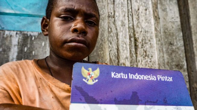 Melfin Melelen (12 tahun) menunjukkan Kartu Indonesia Pintar (KIP) di Kampung Gudang Garam, SKanto, Keerom, Papua, Kamis (27/8/20).  [ANTARA FOTO/Indrayadi TH]