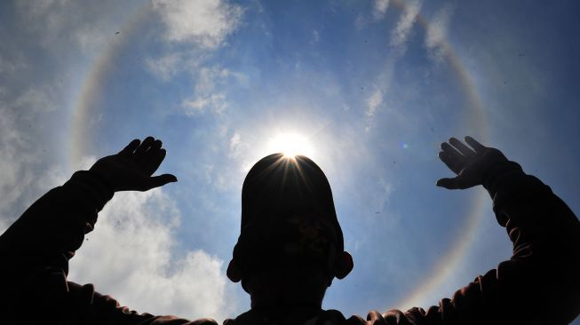 Seorang warga melihat terjadinya Halo Matahari di Kayu Aro Barat, Kerinci, Jambi, Jumat (28/8/2020). [ANTARA FOTO/Wahdi Septiawan]