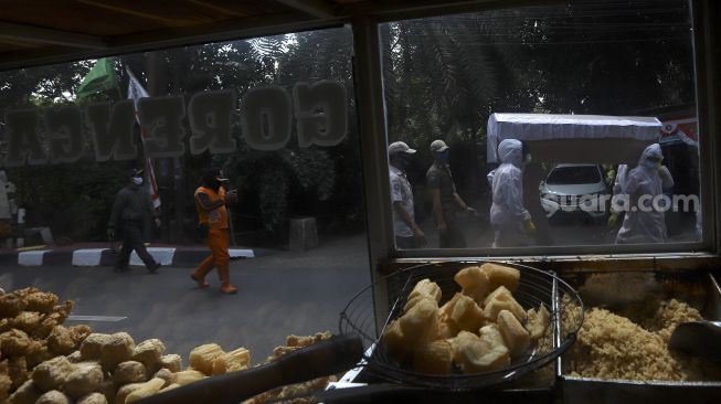 Petugas gabungan dari Kecamatan Cilandak dan Polsek Cilandak melakukan aksi sosialisasi bahaya COVID-19 dengan mengarak instalasi peti mati jenazah di kompleks perumahan di kawasan Fatmawati, Jakarta, Jumat (28/8/2020). [Suara.com/Angga Budhiyanto]