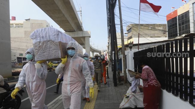 Petugas gabungan dari Kecamatan Cilandak dan Polsek Cilandak melakukan aksi sosialisasi bahaya COVID-19 dengan mengarak instalasi peti mati jenazah di kawasan Fatmawati, Jakarta, Jumat (28/8/2020). [Suara.com/Angga Budhiyanto]