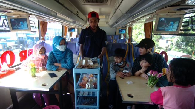 Pelayan menawarkan makanan dan minuman kepada pengunjung "angkringan on the bus" di Pemalang, Jawa Tengah, Jumat (28/8/2020). [ANTARA FOTO/Oky Lukmansyah]