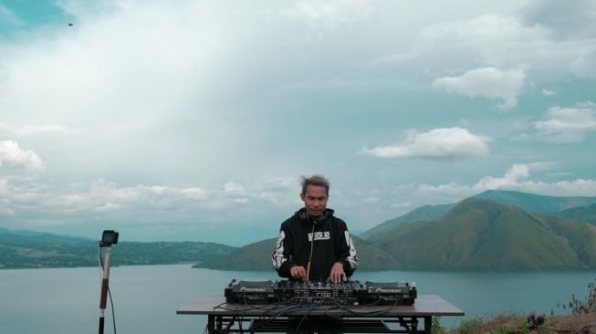 DJ CLIFFrs beraksi dengan latar belakang indahnya alam Danau Toba.