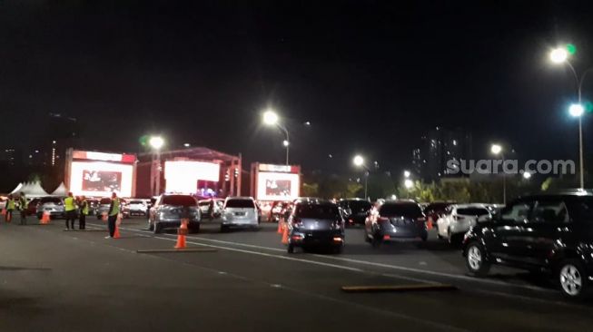 Mobil mengantre masuk di konser drive-in New Live! Experience, yang berlangsung di JIExpo, Kemayoran, Jakarta Utara, Sabtu (29/8/2020) malam. [Yuliani/Suara.com]