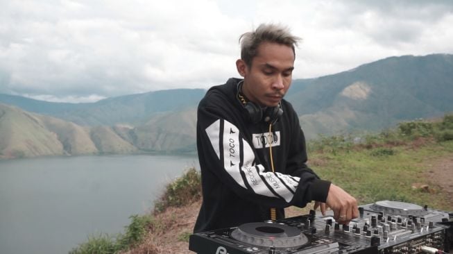 DJ CLIFFrs beraksi dengan latar belakang indahnya alam Danau Toba.