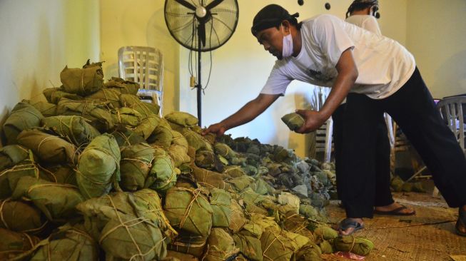 Petugas menata nasi jangkrik untuk dibagikan saat Tradisi Membagi Nasi Jangkrik di kawasan Masjid Menara Kudus, Jawa Tengah, Sabtu (29/8/2020). [ANTARA FOTO/Yusuf Nugroho]