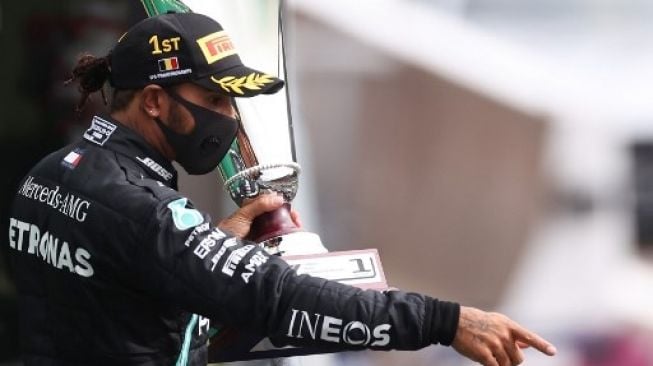 Pembalap Mercedes Lewis Hamilton merayakan suksesnya menjadi juara F1 GP Belgia di atas podium di sirkuit Spa-Francorchamps. Lars Baron / POOL / AFP