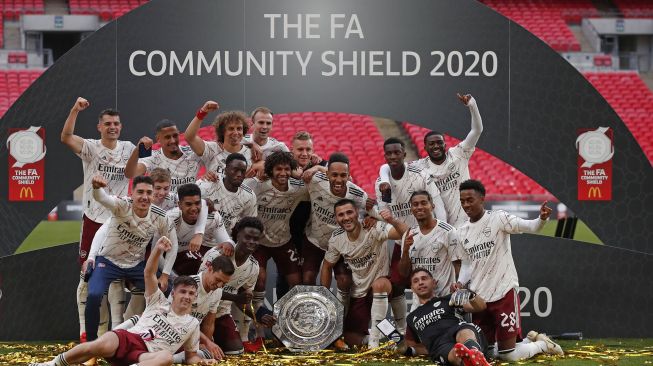 Pemain Arsenal merayakan sukses merebut trofi Community Shield ketika event yang menjadi pembuka musim baru dimainkan di Wembley Stadium, London, Sabtu (29/8).  [ANDREW COULDRIDGE / POOL / AFP]