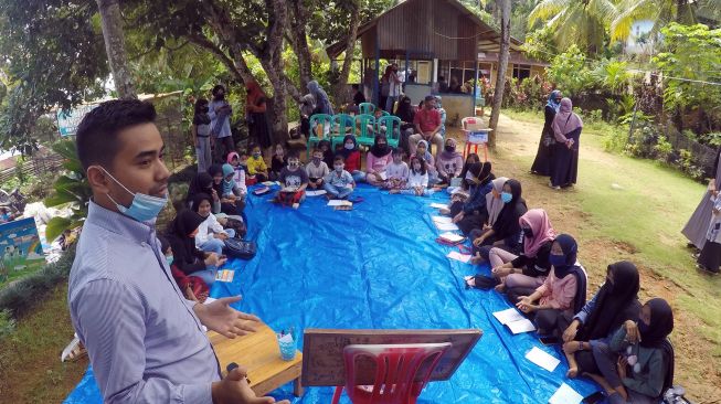 Sejumlah relawan mengajarkan Bahasa Inggris bagi remaja dan anak-anak di Kampung KB, Bukit Gado-Gado, Padang, Sumatera Barat, Minggu (30/8/2020).  [ANTARA FOTO/Iggoy el Fitra]