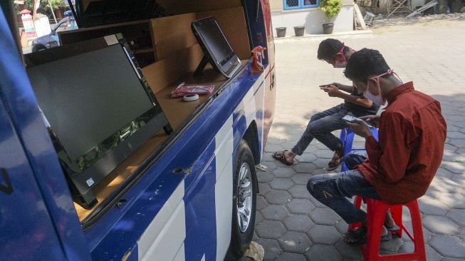 Sejumlah pelajar dan warga memanfaatkan jaringan internet gratis dari Dinas Komunikasi dan Informatika di Kelurahan Medono, Pekalongan, Jawa Tengah, Senin (31/8/2020).[ANTARA FOTO/Harviyan Perdana Putra]