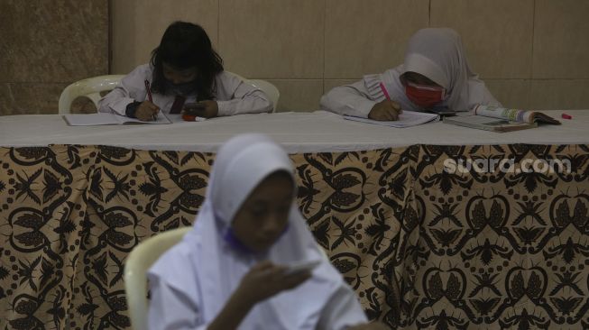 Sejumlah siswa melakukan pembelajaran secara online atau daring di RW 001 Kelurahan Galur, Johar Baru, Jakarta, Senin (31/8/2020). [Suara.com/Angga Budhiyanto]