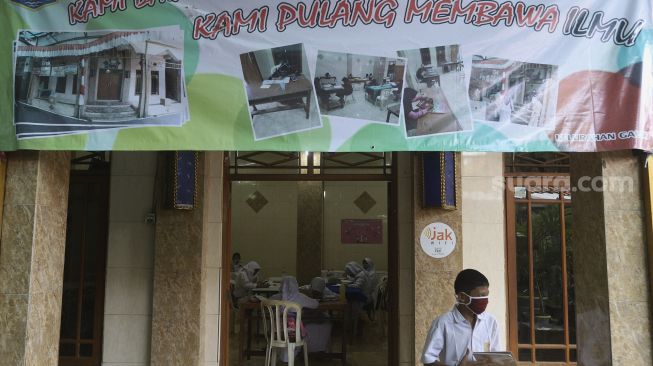 Sejumlah siswa melakukan pembelajaran secara online atau daring di RW 001 Kelurahan Galur, Johar Baru, Jakarta, Senin (31/8/2020). [Suara.com/Angga Budhiyanto]