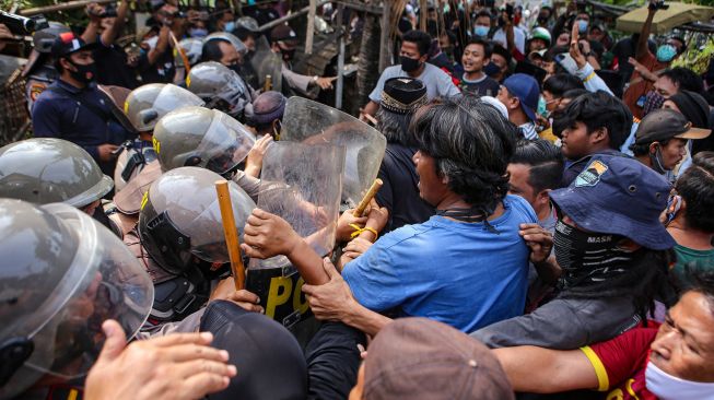 Petugas kepolisian dan warga saling dorong saat eksekusi lahan untuk pembangunan tol JORR 2 di Benda, Kota Tangerang, Banten, Selasa (1/9/2020).  [ANTARA FOTO/Fauzan]