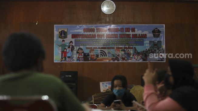 Sejumlah pelajar dari berbagai jenjang sekolah mengerjakan tugas dengan metode pembelajaran jarak jauh menggunakan fasilitas Wi-Fi gratis di balai warga RW 005 Kelurahan Kuningan Barat, Jakarta, Selasa (1/9/2020). [Suara.com/Angga Budhiyanto]