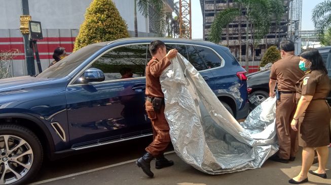 Mobil mewah BMW SUV X 5 berwarna biru milik Jaksa Pinangki Sirna Malasari dipasang garis Kejaksaan, di Kejaksaan Agung RI, Jakarta, Selasa (1/9/2020). [Suara.com/Arga]