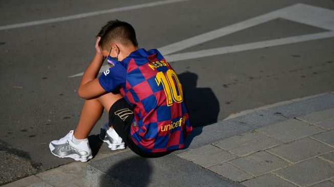 Fans cilik Barcelona menunggu di luar Ciutat Esportiva Joan Gamper, Barcelona, Spanyol, Minggu (30/8). [PAU BARRENA / AFP]