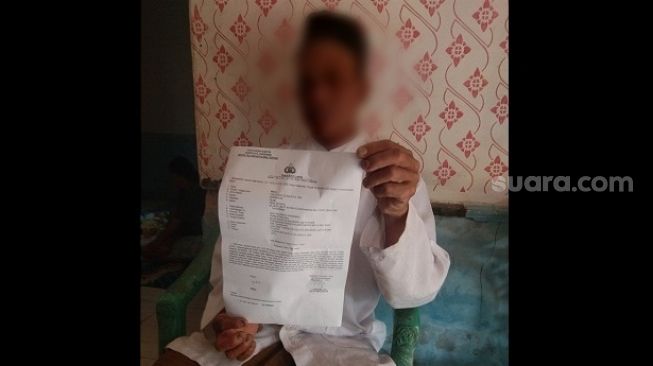 Orang tua korban berinsial D menunjukkan bukti laporan polisi terkait kasus pencabulan yang menimpa putrinya saat ditemui di kediamannya di Kabupaten Tangerang, Banten, Rabu (2/9/2020). [Suara.com/Ridsha Vimanda Nasution]