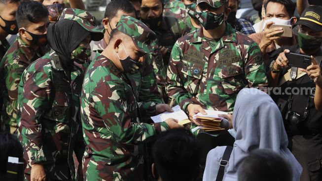 Panglima Kodam Jaya, Mayjen TNI Dudung Abdurachman (ketiga kiri) memberikan ganti rugi kepada warga sipil yang menjadi korban penyerangan Mapolsek Ciracas di Koramil 05 Kramat Jati, Jakarta, Rabu (2/9/2020). [Suara.com/Angga Budhiyanto] 