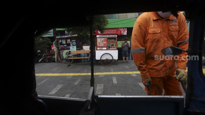 Petugas PPSU membersihkan trotoar di kawasan Jalan Kramat Raya, Jakarta, Rabu (2/9/2020). [Suara.com/Angga Budhiyanto]