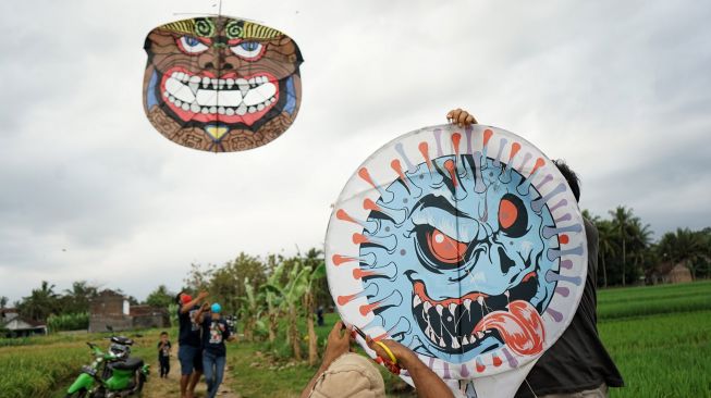 Warga bersiap menerbangkan layang-layang bertema virus corona di Ngaran, Margokaton, Seyegan, Sleman, D.I Yogyakarta, Rabu (2/8/2020). [FOTO/Andreas Fitri Atmoko]