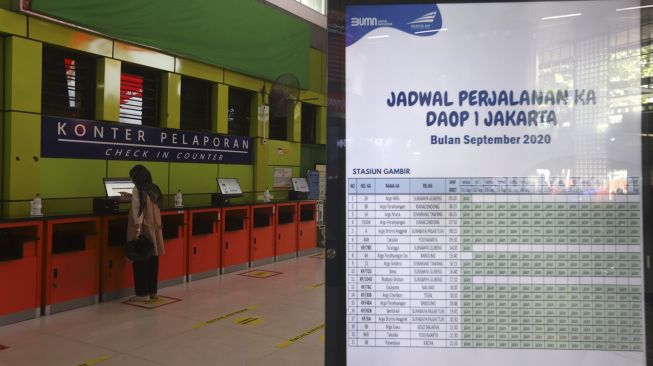 Seorang calon penumpang mencetak tiket kereta api di Stasiun Gambir, Jakarta, Kamis (3/9/2020). [Suara.com/Angga Budhiyanto]