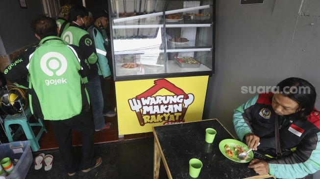 Sejumlah pengemudi ojek online mengantre untuk menikmati hidangan makan gratis di Warung Makan Rakyat, Beji, Depok, Jawa Barat, Kamis (3/9/2020). [Suara.com/Angga Budhiyanto]