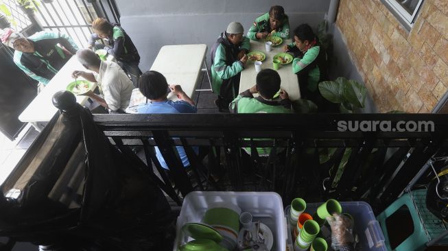 Sejumlah pengemudi ojek online menikmati hidangan makan gratis di Warung Makan Rakyat, Beji, Depok, Jawa Barat, Kamis (3/9/2020). [Suara.com/Angga Budhiyanto]