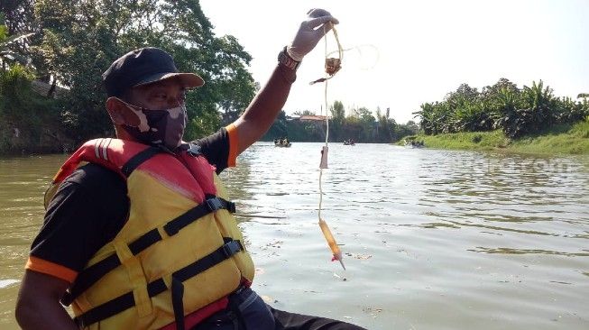 Aktivis Bank Sasuci saat menemukan limbah yang diduga bekas penanganan Covid-19 di aliran Sungai Cisadane, Jumat (4/9/2020). [Suara.com/Irfan Maulana]