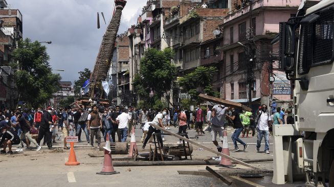 Sejumlah warga bentrokan dengan polisi setelah pihak berwenang berusaha menghentikan prosesi kereta Buddha tahunan Rato Machindranath di Lalitpur, Nepal (3/9/2020). [PRAKASH MATHEMA / AFP]