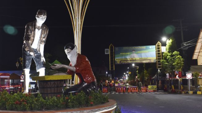 Petugas menutup jalan di Kota Madiun, Jawa Timur, Kamis (3/9/2020) malam. [ANTARA FOTO/Siswowidodo]