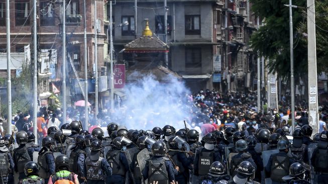 Sejumlah warga melempar batu selama bentrokan dengan polisi setelah pihak berwenang berusaha menghentikan prosesi kereta Buddha tahunan Rato Machindranath di Lalitpur, Nepal (3/9/2020). [PRAKASH MATHEMA / AFP]