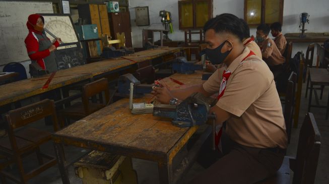 Sejumlah siswa SMK Negeri 3 jurusan teknik jaringan tenaga listrik mengikuti pembelajaran praktik secara tatap muka di Kabupaten Jombang, Jawa Timur, Jumat (4/9/2020). [ANTARA FOTO/Syaiful Arif]